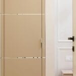 Jasny, minimalistyczny korytarz z zabudowanymi szafami i gładkimi drzwiami