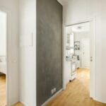 Jasny skandynawski przedpokój z białymi ścianami i drewnianą podłogą