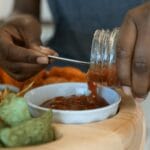 Domowa salsa nalewana do miski obok chipsów tortilla