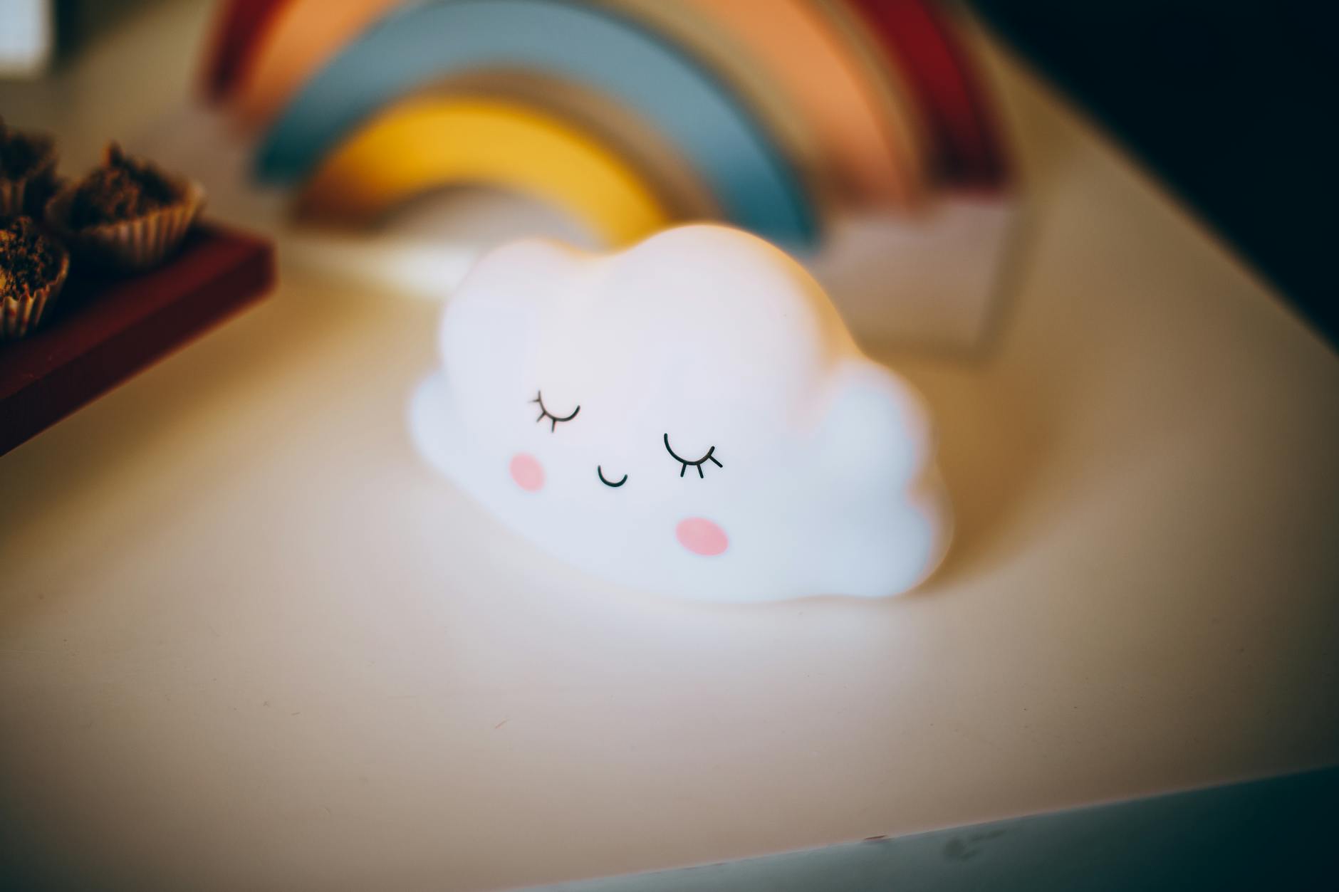 Lampka nocna w kształcie chmurki na tle tęczy w pokoju dziecka