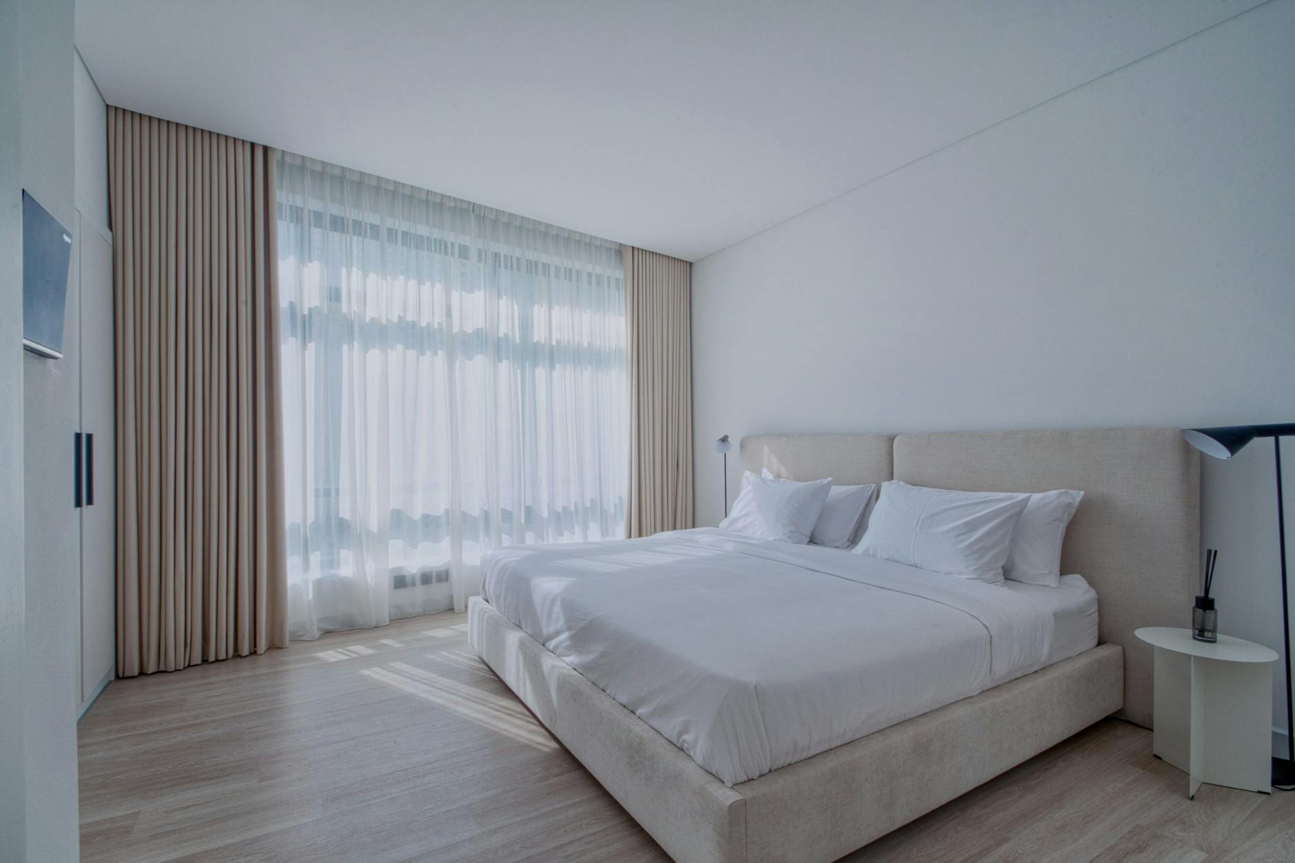 Nowoczesna, jasna sypialnia z łóżkiem i dużym oknem