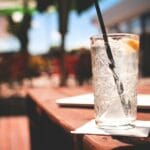 Kieliszek ginu z tonikiem i plasterkiem cytryny na letnim tarasie