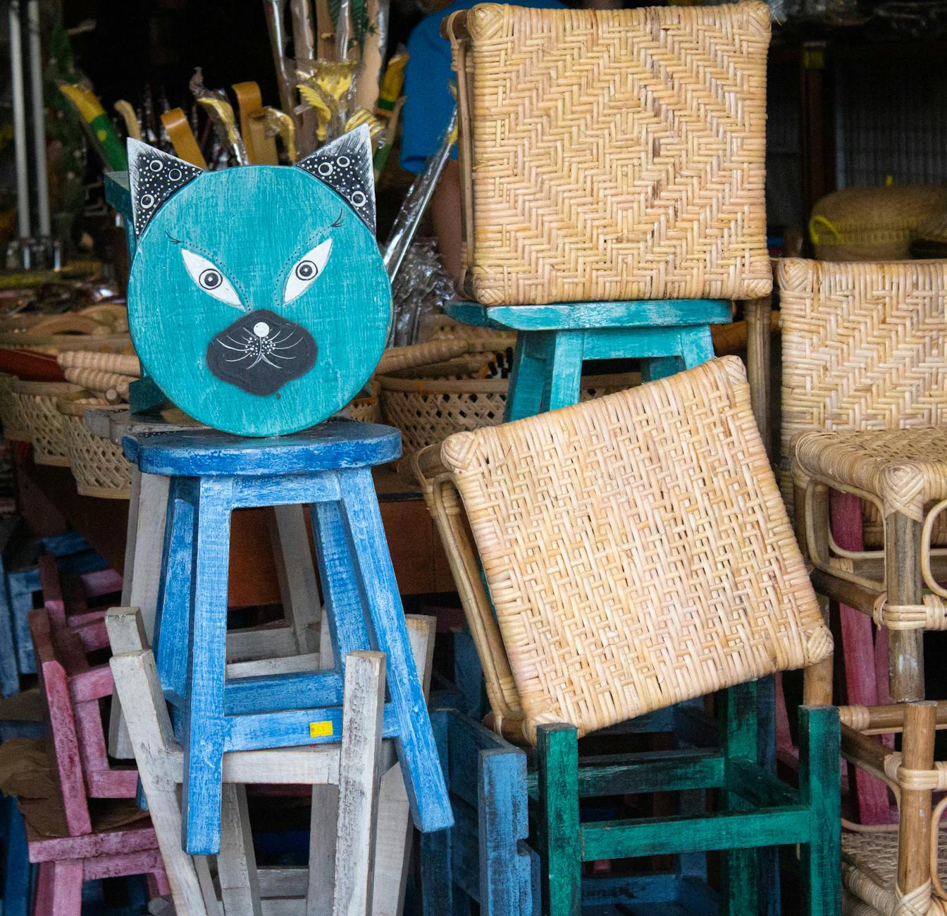 Kolorowe wiklinowe krzesła i drewniane stołki na targu z rękodziełem