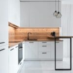 Nowoczesna biała kuchnia z wiszącymi geometrycznymi lampami