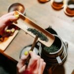 Dłonie przygotowujące liście zielonej herbaty do tradycyjnej ceremonii