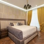 Elegancka sypialnia z pikowanym łóżkiem i kryształowym żyrandolem
