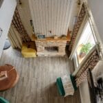 Salon z kominkiem, nowoczesnymi meblami i drewnianą podłogą