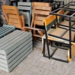 Stosy drewnianych ławek i krzeseł na metalowych ramach na zewnątrz