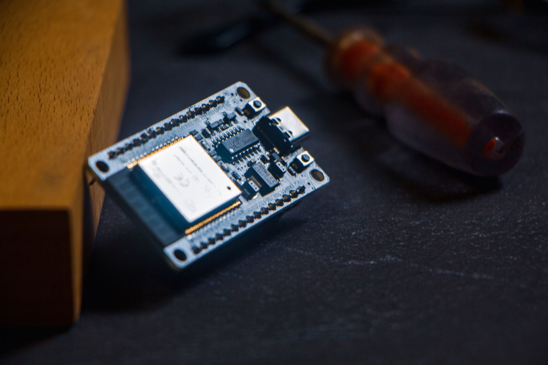 Mikrokontroler Arduino na ciemnym tle obok małego śrubokręta