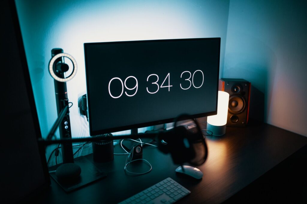 Nowoczesne biurko z dużym monitorem, zegarem cyfrowym i oświetleniem LED
